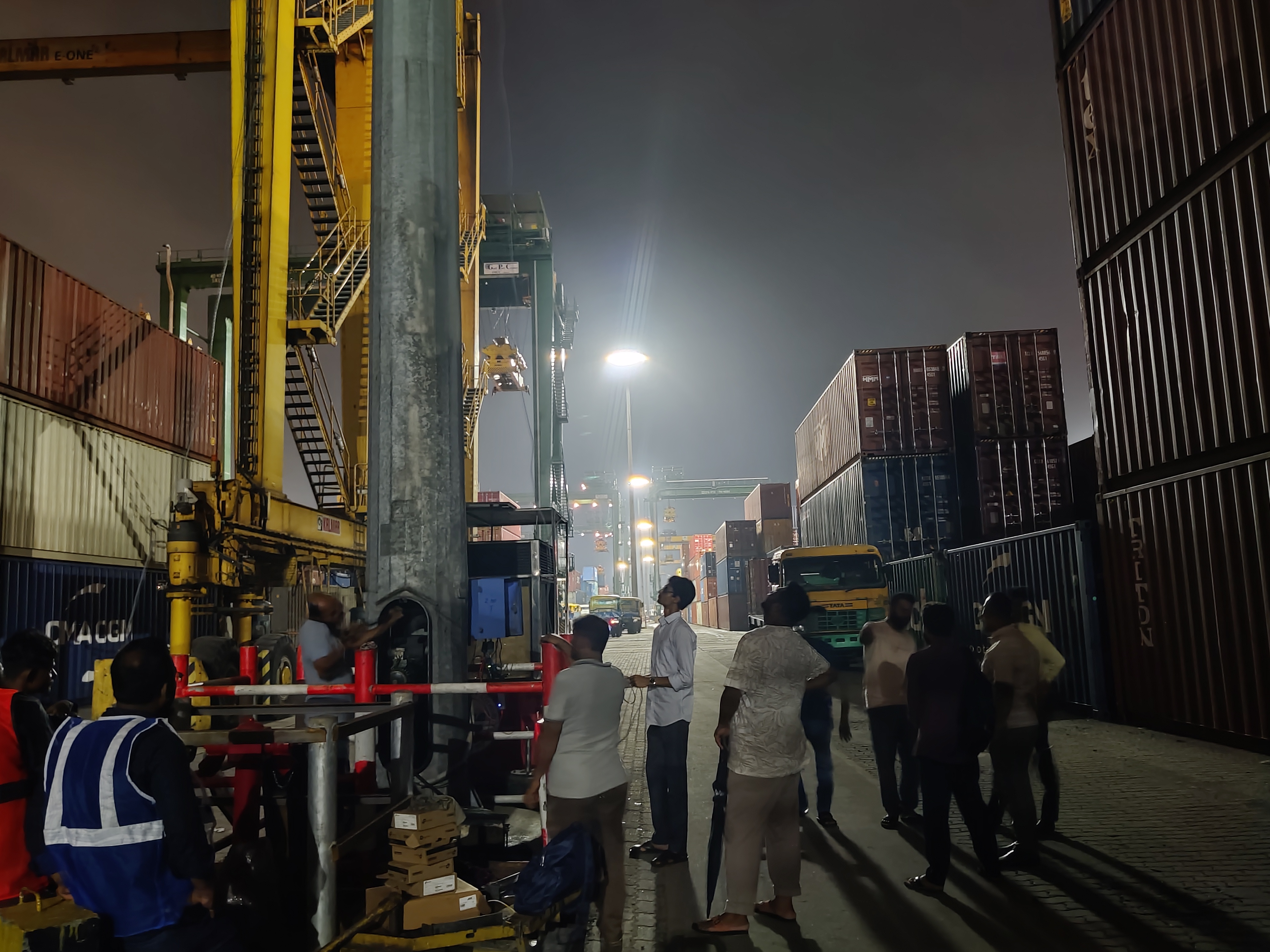 Troubleshooting a technical issue at a quay crane at night with the team
